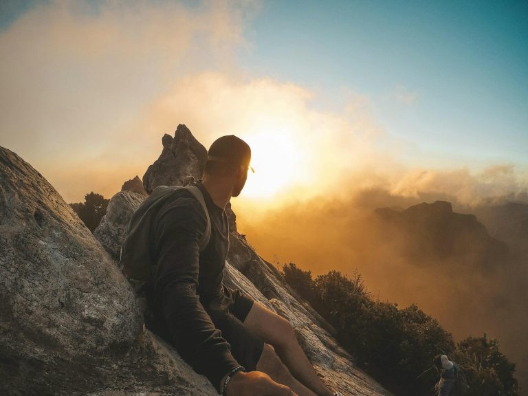 Guy sitting on mountain watching sunset - how to recover from a porn addiction